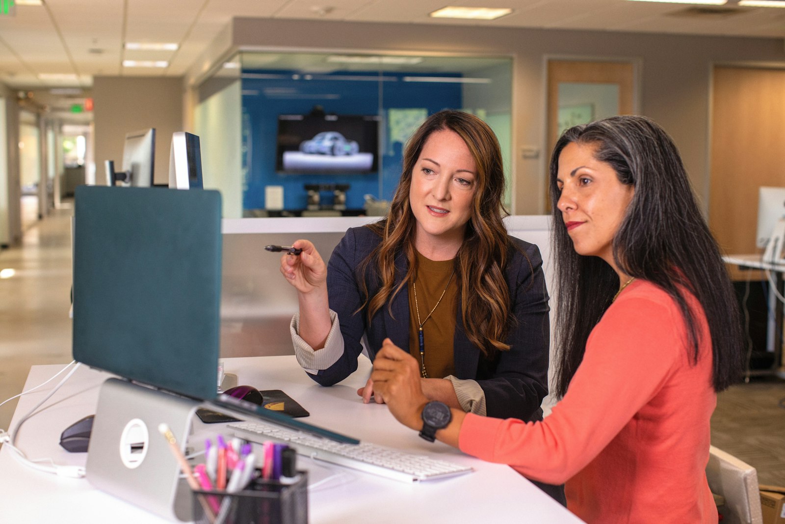 Two professionals reviewing a profile on a laptop