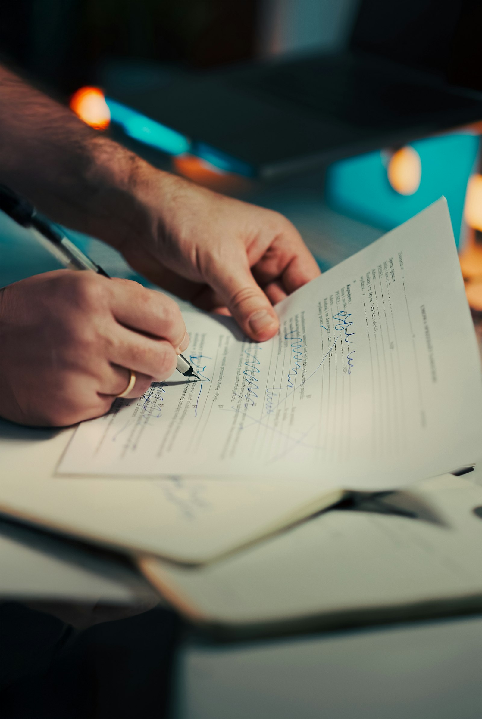 Close-up of a hand signing and reviewing a document