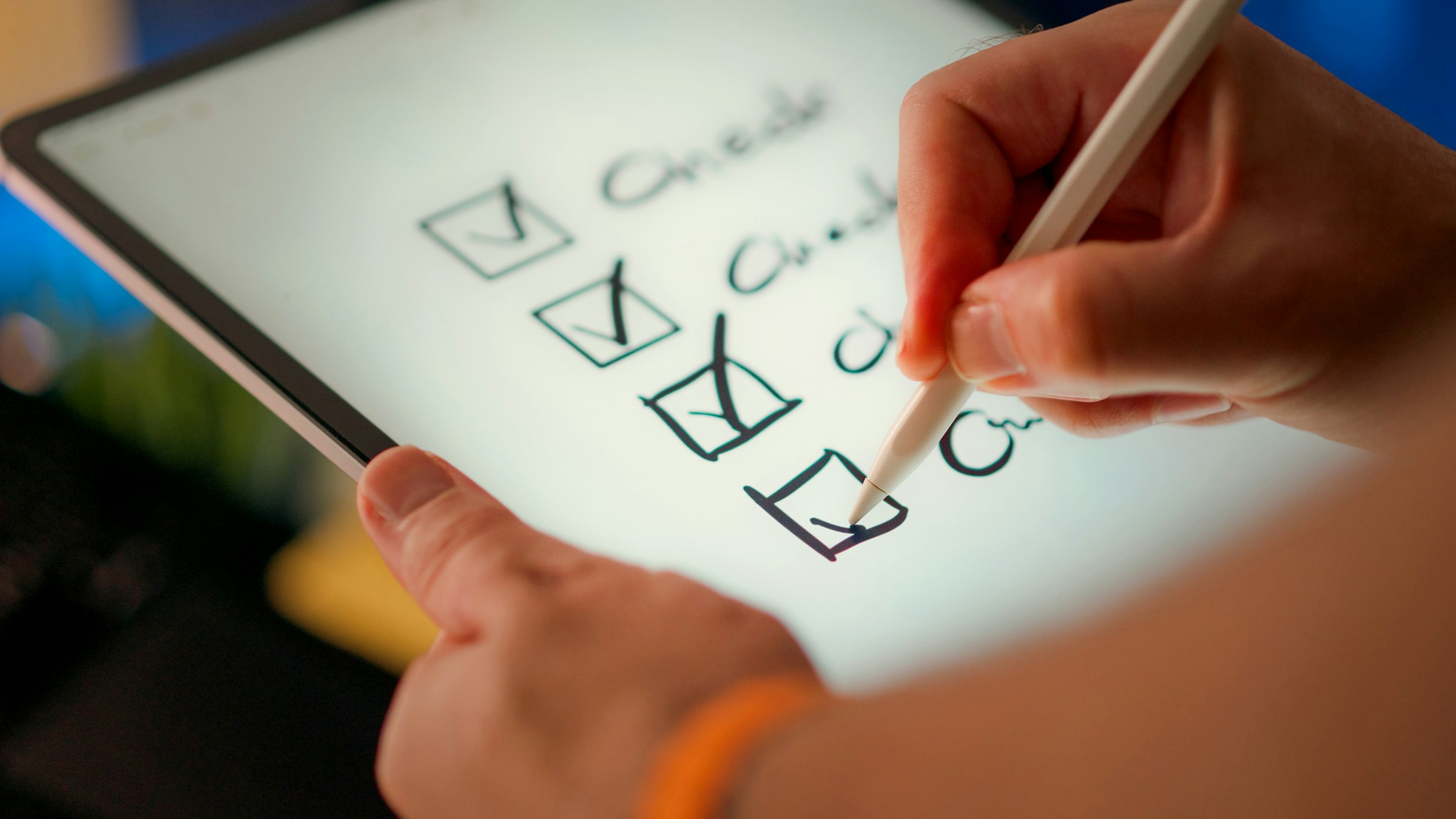 A hand ticking off completed items on a digital checklist on a tablet screen