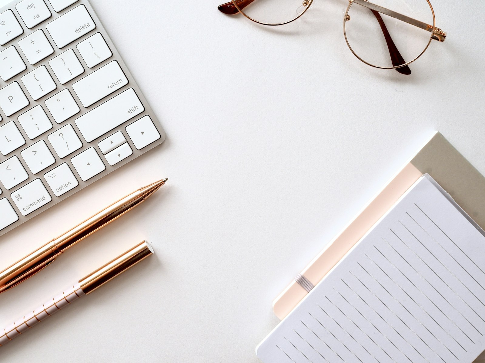 A pen resting on paper next to a pair of eyeglasses, symbolizing resume editing