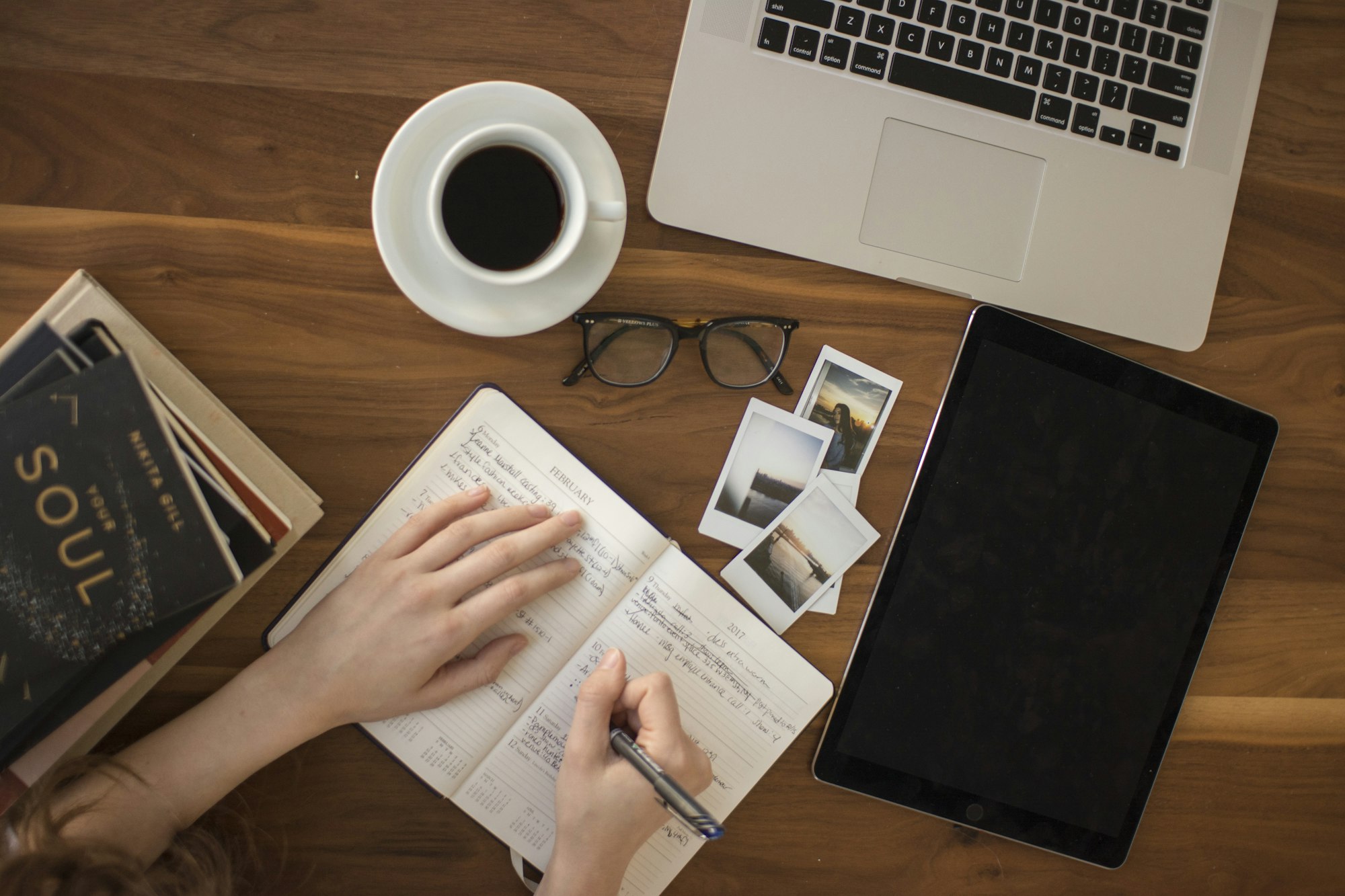 A person holding a ballpoint pen while writing by hand in a notebook