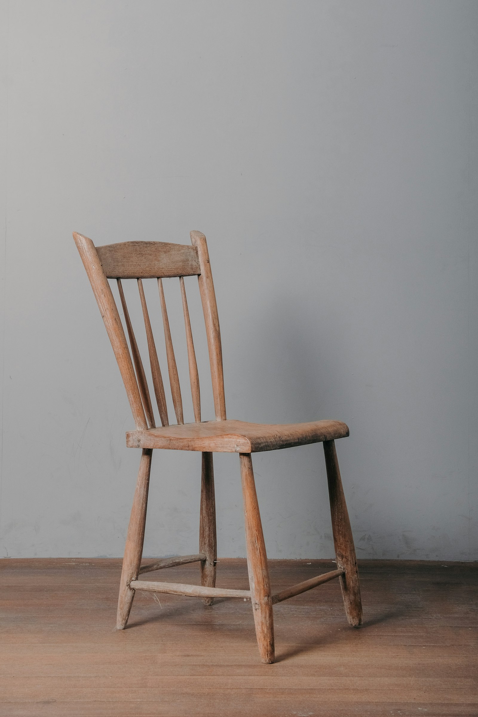 A finished wooden chair resting on a wooden floor