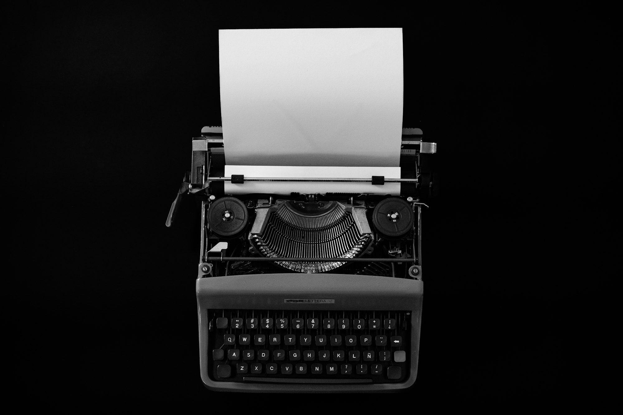 Close-up of a vintage typewriter with a blank sheet of paper loaded and ready to type